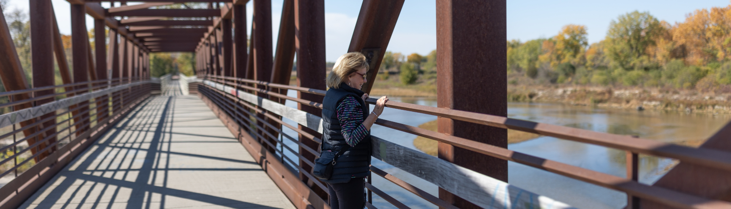 Image of a woman and a dog overlooking the Elkhorn River in Norfolk Nebraska