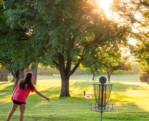 Gal throwing a disc golf frisbee