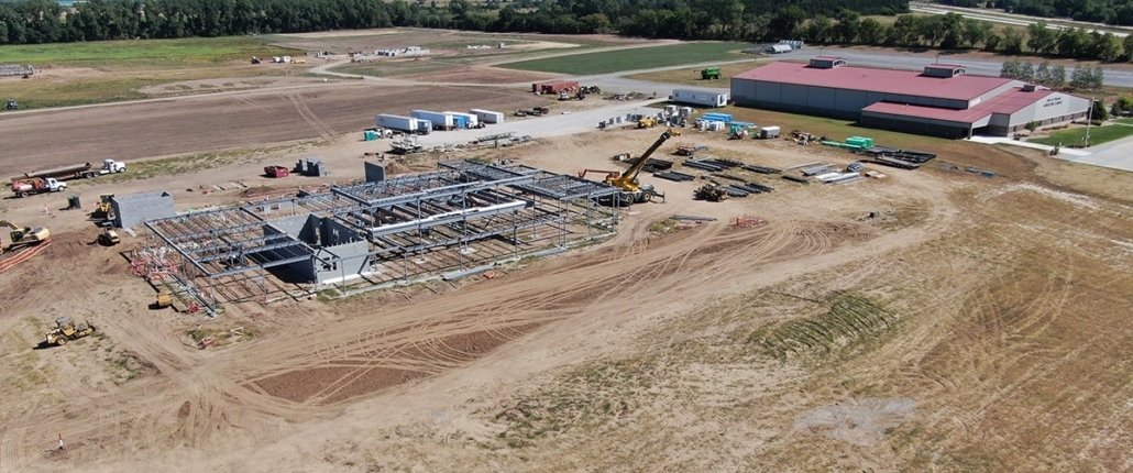Aerial photo of new construction with the Chuck M. Pohlman Ag Complex in the distance